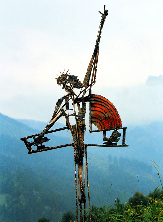 Grabkreuz-Skulptur mit einer Cristus-Figur die den Weg weist